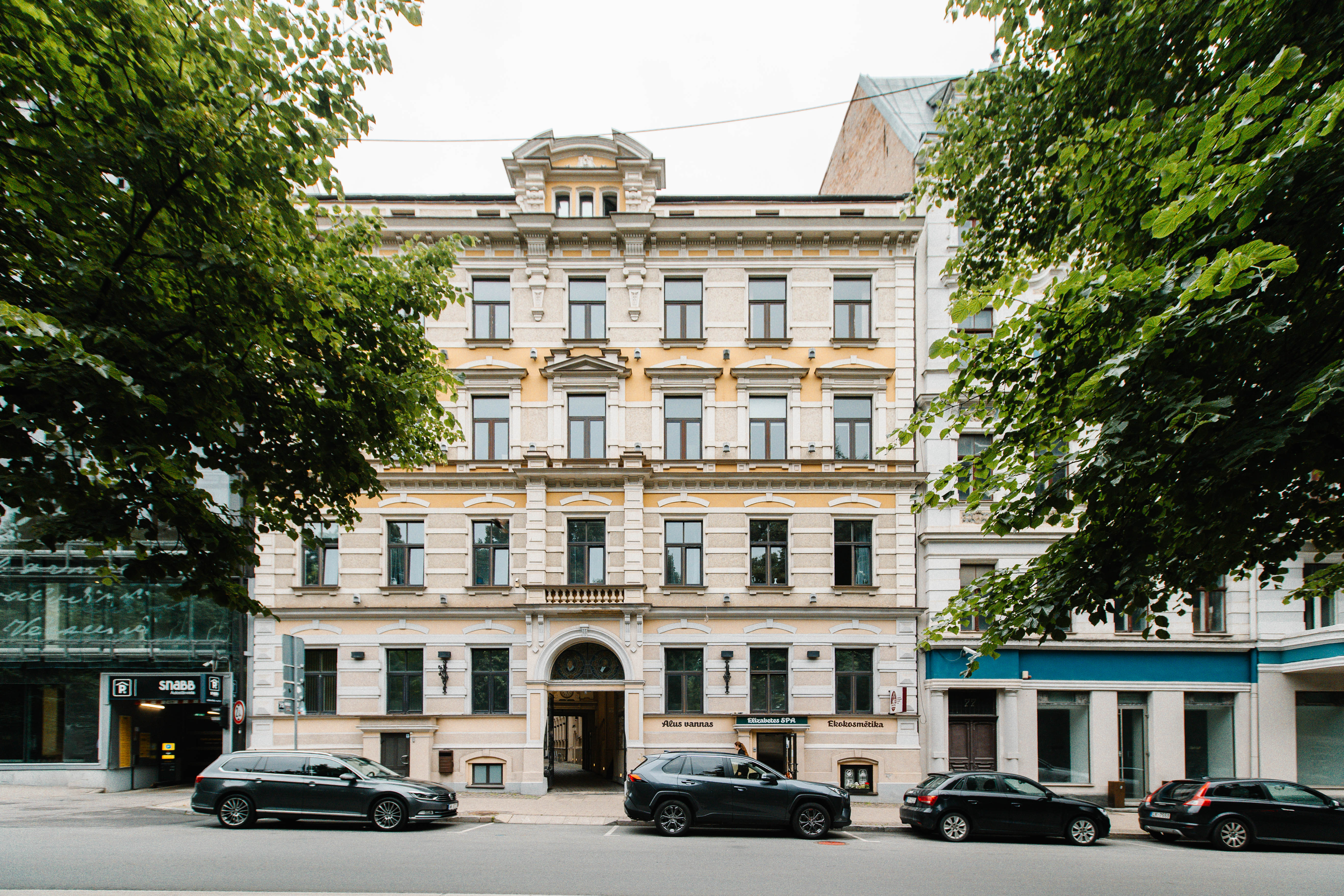 BARBERS HUB pašu uzņemta Elizabetes ielas 75 fasādes fotogrāfija ar ieejas un blakus esošās pazemes stāvvietas norādēm